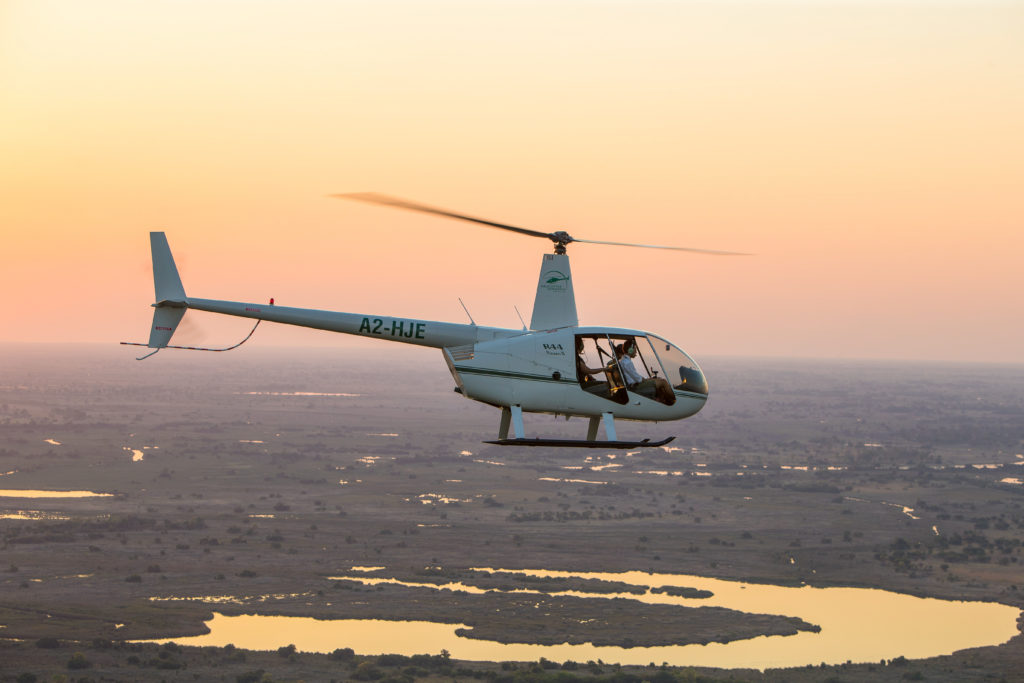 Flying over the Okavango Delta, Botswana in a helicopter without doors